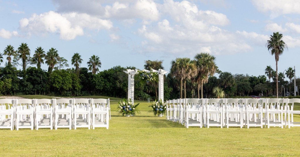Palm Beach wedding venue ceremony with waterfront views and tropical greenery
